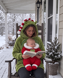 Reading on a snowy porch with baby zipped in